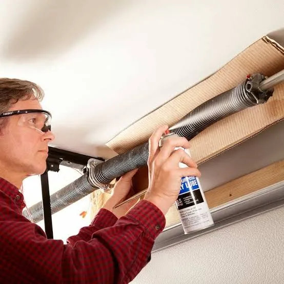 Technician performing garage door maintenance